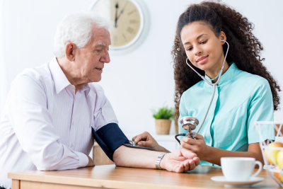 Nurse taking old woman blood pressure